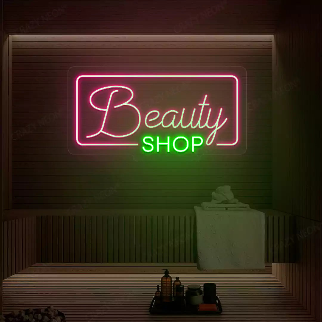 Pink and green Beauty Shop neon sign glowing on a wooden wall