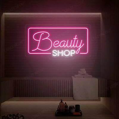 Pink and white Beauty Shop neon sign glowing on a wooden wall