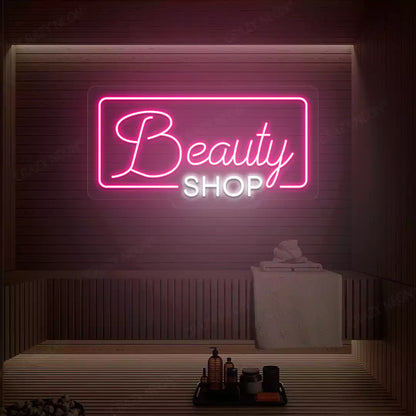 Pink and white Beauty Shop neon sign glowing on a wooden wall