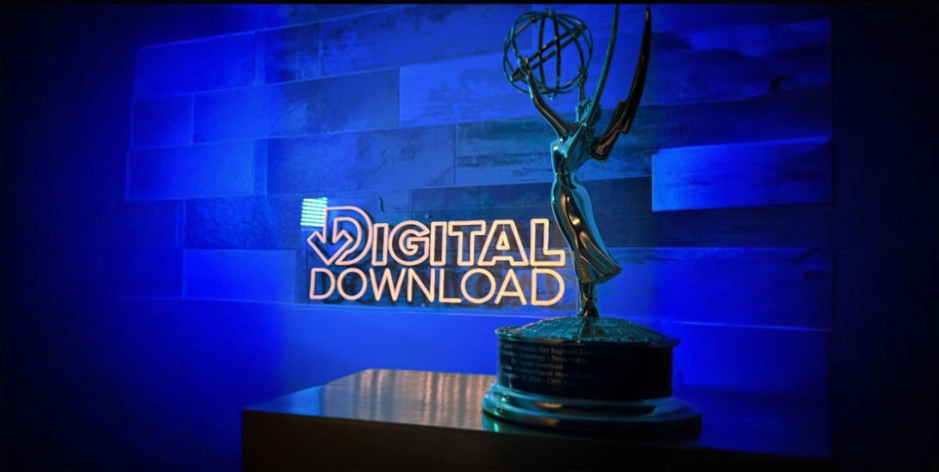 Emmy Award trophy displayed on a table in front of a glowing neon sign that reads 'DIGITAL DOWNLOAD' against a blue-lit tiled wall