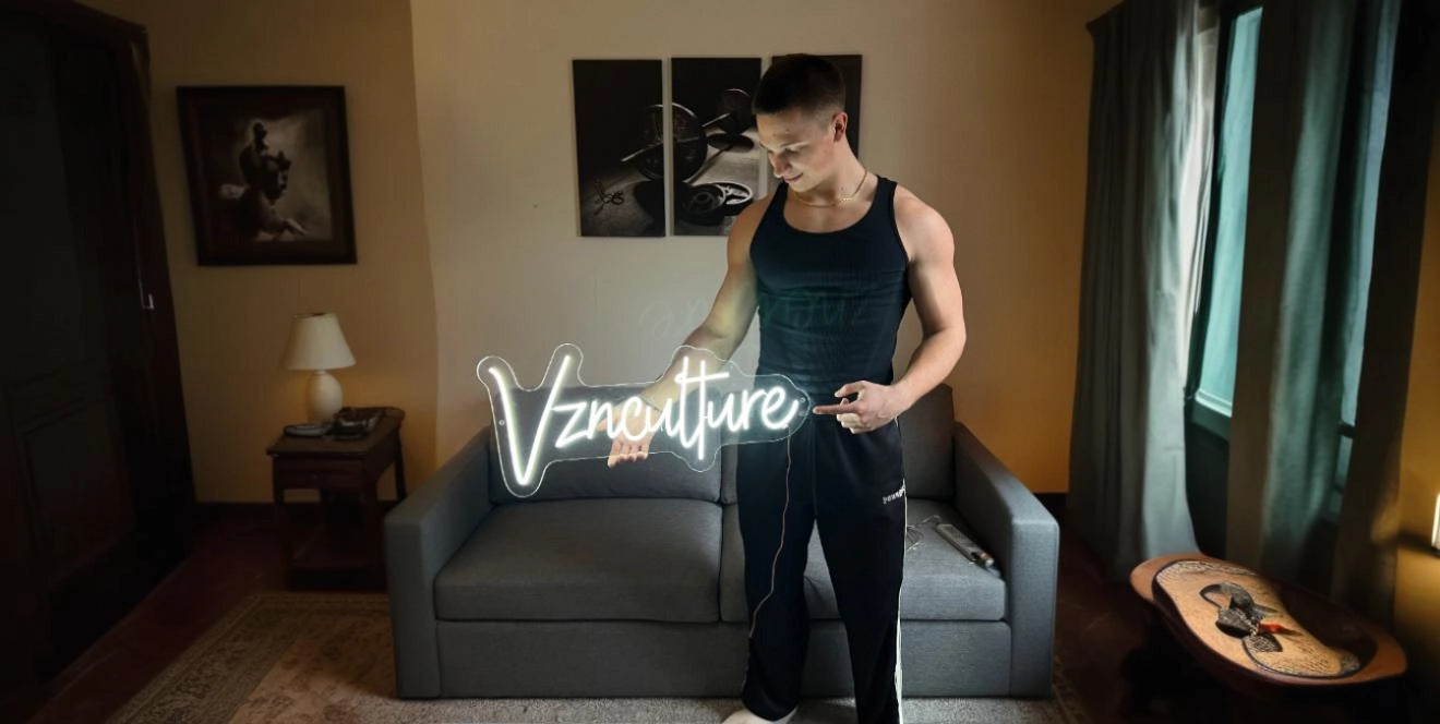 Man holding Vznculture gym neon sign in modern workout room