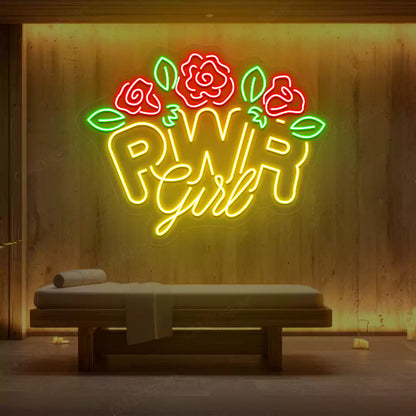 Yellow PWR Girl Floral neon sign glowing on a wooden wall
