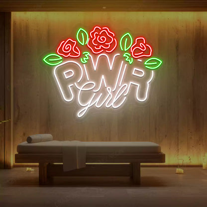 White PWR Girl Floral neon sign glowing on a wooden wall