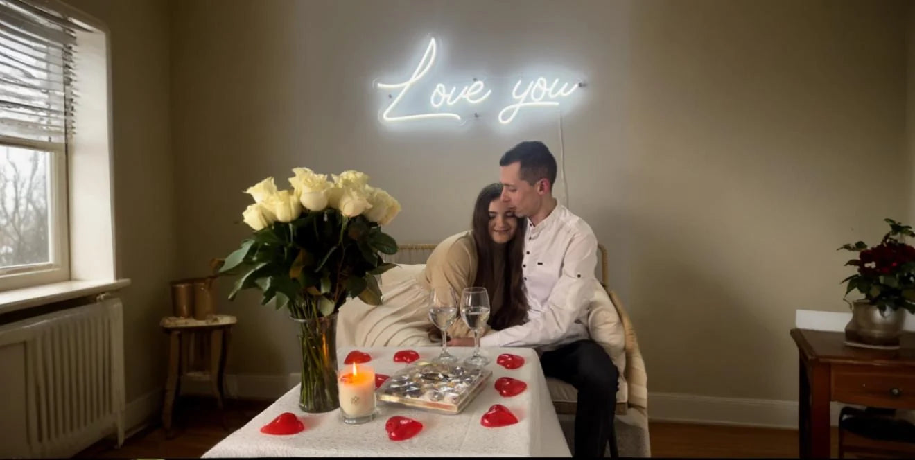Love you neon sign glowing above couple sharing romantic moment 