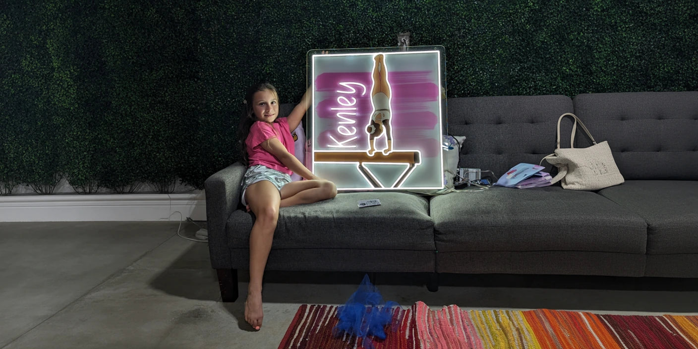 Kenley custom gymnastics neon sign with girl doing handstand on beam beside smiling girl on sofa kids room wall decor lighting