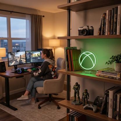 Green Xbox neon lamp on a modern office desk beside a laptop, notebook, and workspace essentials in a professional cubicle setting.
