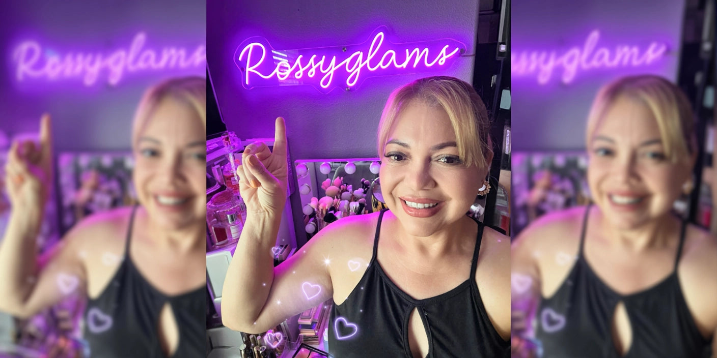 Blonde woman pointing at Rossyglams purple neon sign in beauty salon with makeup vanity and perfumes